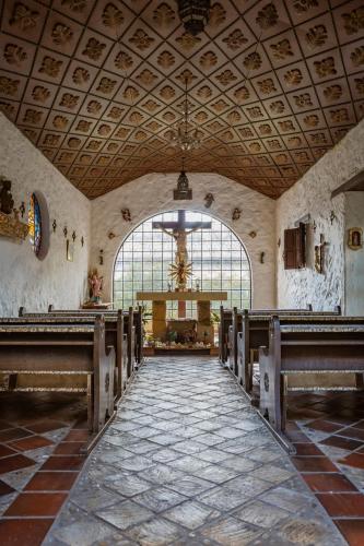 a large church with a large window and wooden pews at Hacienda Coloma in Fusagasuga