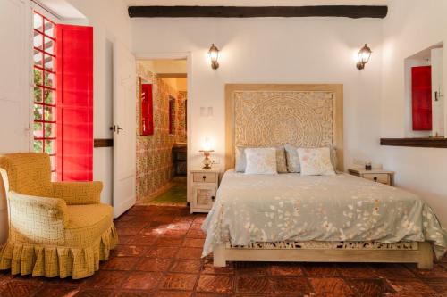 a bedroom with a bed and a chair at Hacienda Coloma in Fusagasuga
