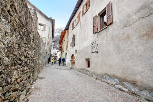 people walking down a cobblestone alley between two buildings at Premesan 5 in Bormio
