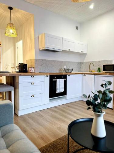 La cuisine est équipée de placards blancs et d'un four micro-ondes noir. dans l'établissement Le Bohème Chic - Gare sud Rennes, à Rennes