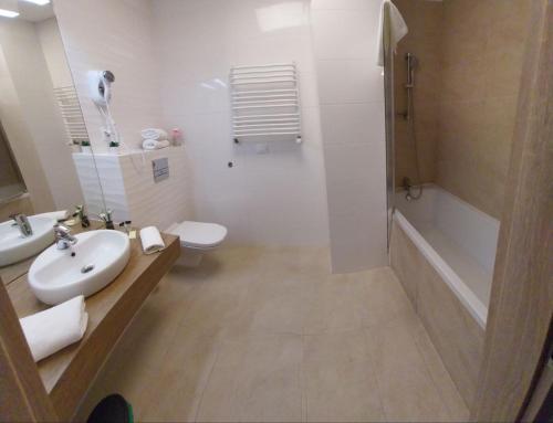 a bathroom with a sink and a toilet and a shower at Zlatarooms 130 in Warsaw