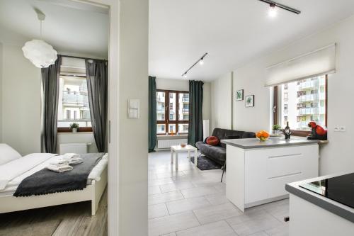 Cet appartement comprend une chambre avec un lit, une cuisine et un salon. dans l'établissement Warsaw Night Apartments Giełdowa, à Varsovie