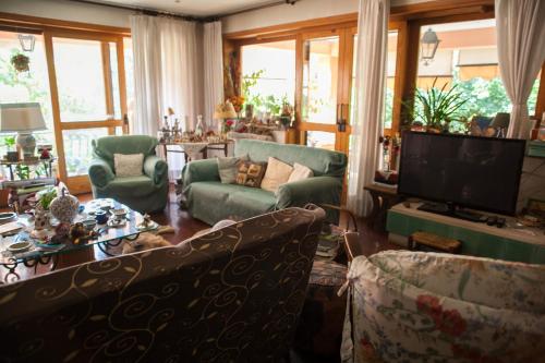 un soggiorno con divani e TV a schermo piatto di B&B Villa il Noce a Picinisco