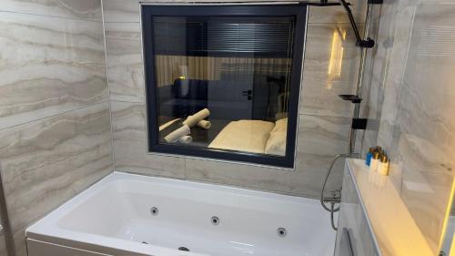 a bath tub in a bathroom with a mirror at Wonne Boutique Hotel Spa in Ankara