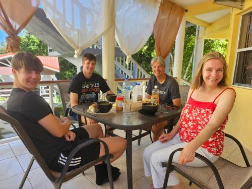 eine Gruppe von Menschen, die an einem Tisch sitzen in der Unterkunft Royal Escape in Anse La Raye