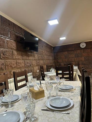 a dining room with a table with plates and glasses at Colibri Hotel in Haghpat