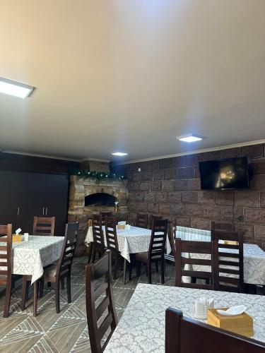 a dining room with tables and chairs and a brick wall at Colibri Hotel in Haghpat