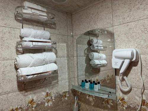 a bathroom with towels and a phone on a wall at Colibri Hotel in Haghpat