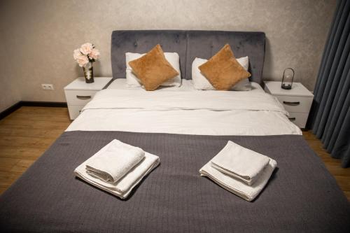 1 cama grande con toallas blancas y almohadas. en Center Home Apartment, en Chişinău
