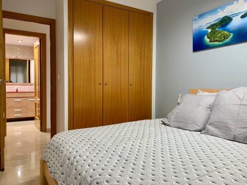 um quarto com uma cama e um armário de madeira em Experience Valencia Bnb - Rincon del Mar - Apartamento Maravilloso a Canet Playa 100 mt em Canet d'En Berenguer