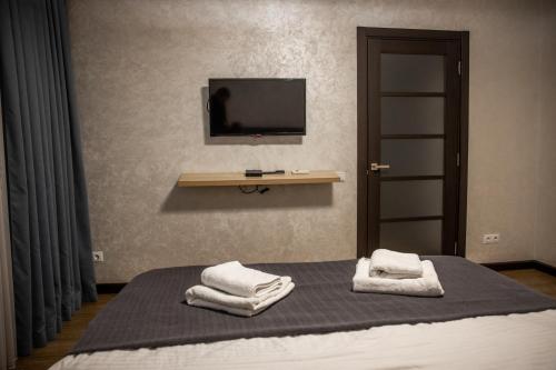 1 dormitorio con 1 cama con toallas en Center Home Apartment, en Chişinău