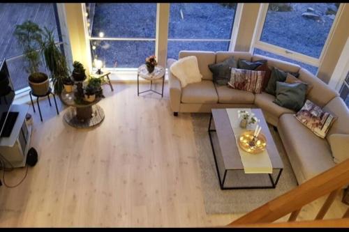 a living room with a couch and a table at Fjordcabin Panoramic view Near Bergen 3 sleepingroom in Forland