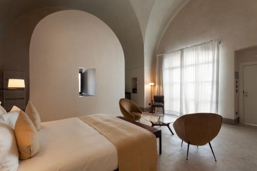 Cette chambre comprend un grand lit et une fenêtre. dans l'établissement Palazzo Tafuri, à Nardò