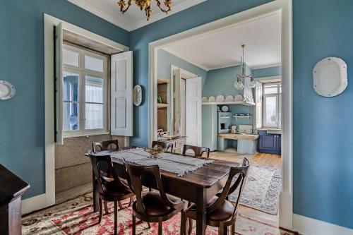 a dining room with a wooden table and chairs at Casa da Avó in Caminha