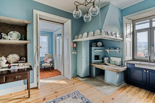 a blue kitchen with a sink and a window at Casa da Avó in Caminha