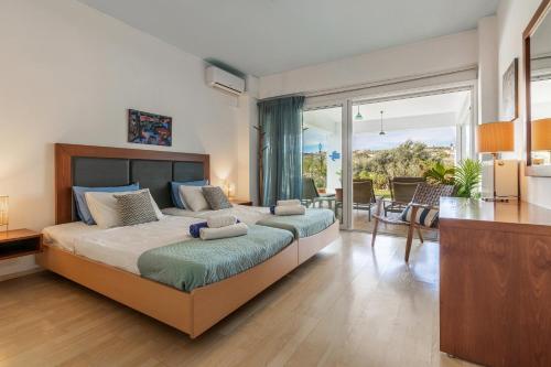 a bedroom with a large bed with a large window at WhiteBlue Spa Villa, By IdealStay Experience in Heraklio Town