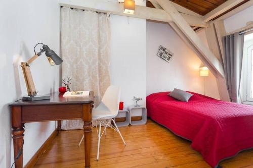 尼斯的住宿－MY CASA - ETATS_UNIS 896 - OPERA -Magic view w/rooftop terrace，一间卧室配有书桌和一张带红色床罩的床。