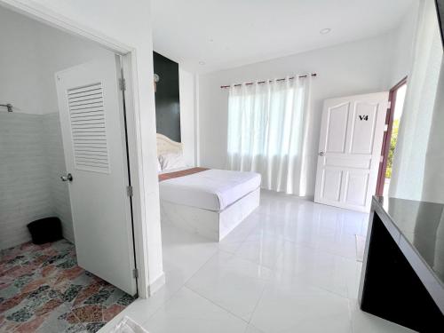 Habitación blanca con cama y ventana en Rim Suan Resort, en Satun