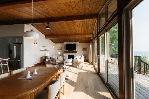 ein Esszimmer mit einem Tisch und ein Wohnzimmer in der Unterkunft Newly reno Classic Lake Front Cottage with Dock in Sylvan Lake