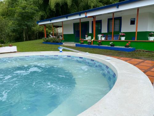 a large swimming pool in a yard with a house at Macondo casa café in Salento
