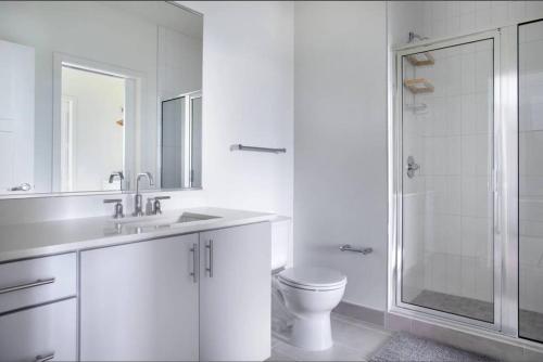 a white bathroom with a toilet and a shower at City Luxury King Suite w coffee station in Alexandria