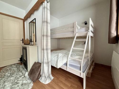 a white bunk bed with a ladder in a room at Appartement chaleureux au ski avec piscine in Orelle