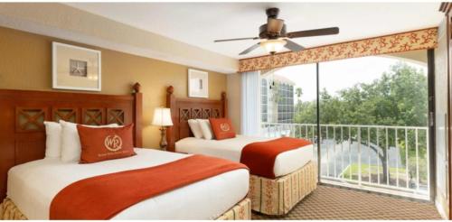 two beds in a hotel room with a balcony at Westgate Towers Resort in Orlando