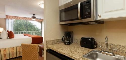 a kitchen with a sink and a bed in a room at Westgate Towers Resort in Orlando