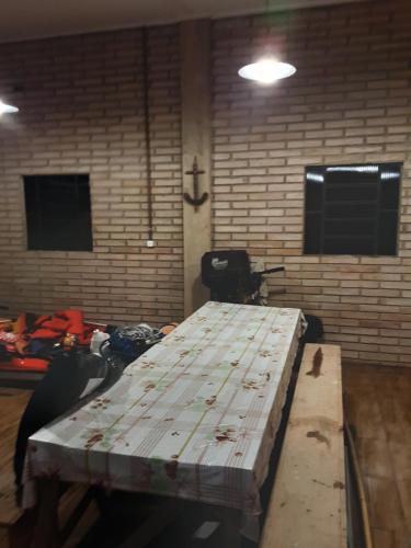 einen Holztisch in einem Zimmer mit Ziegelwand in der Unterkunft Cabana recantodosamigositapua praia dos passarinhos itapua in Viamão