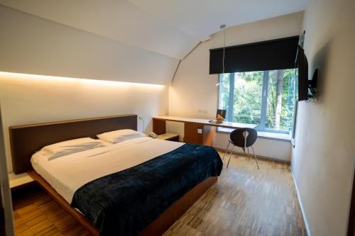 a bedroom with a bed and a desk and a window at Black Hotel in Rome