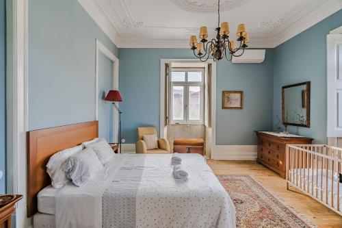 um quarto com uma cama com paredes azuis e um lustre em Casa da Avó em Caminha