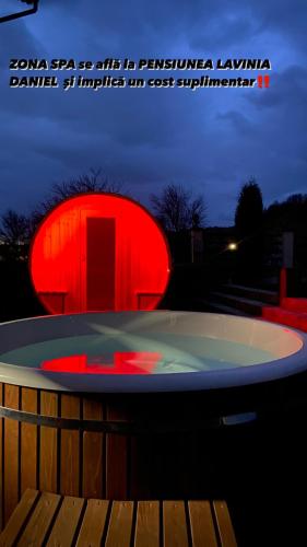 a hot tub with a red light in the night at Cabana Lavinia Daniel in Statiunea Borsa