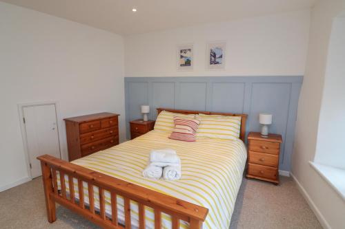 a bedroom with a bed with two towels on it at 1 Bailey's Cottage in Dartmouth
