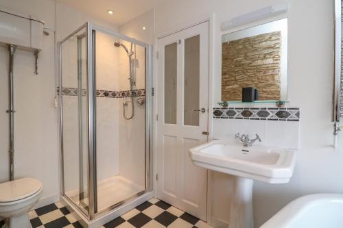uma casa de banho com um chuveiro, um lavatório e um WC. em 1 Bailey's Cottage em Dartmouth
