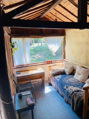 a bedroom with a bed in a room with a window at El Hobbit in Villa General Belgrano