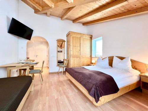 Dormitorio con cama, escritorio y TV en Enjoy Dolomites - Chalet, en Santa Cristina Valgardena