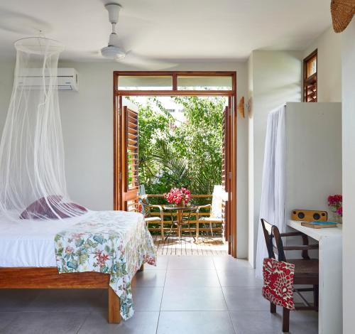 Schlafzimmer mit einem Bett und einer Tür zu einer Terrasse in der Unterkunft Jakes Hotel in Treasure Beach