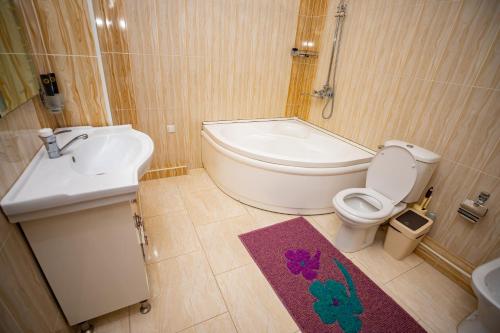 杜尚別的住宿－VATAN DUSHANBE HOTEL，浴室配有卫生间、盥洗盆和浴缸。