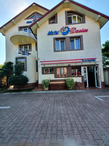 a hotel building with a sign that reads metro beauty at Motel Davios in Târgu Jiu