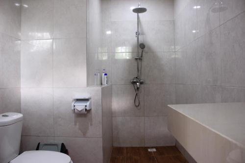 a bathroom with a shower and a toilet and a tub at Private Villa Kayu Padangbai in Padangbai