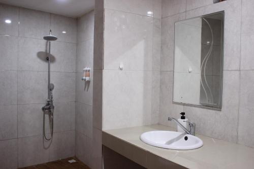 a bathroom with a sink and a shower with a mirror at Private Villa Kayu Padangbai in Padangbai