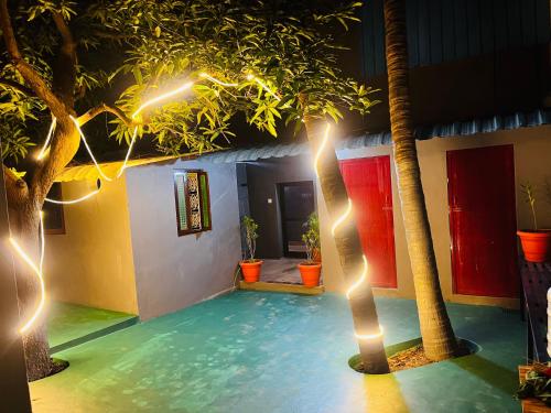 a room with a pool with palm trees and lights at Hostel kuruku santhu colive in Pondicherry