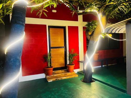 une maison rouge avec des plantes en pot devant elle dans l'établissement Hostel kuruku santhu colive, à Pondichéry