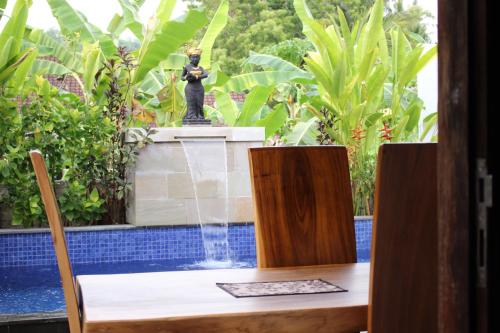 a statue sitting on a table in front of a fountain at Private Villa Kayu Padangbai in Padangbai