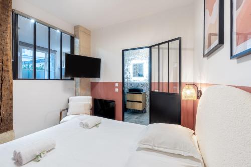 a hotel room with two beds and a tv at NEW Gorgeous Flat-Central Area in Paris