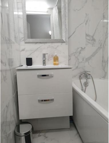 une salle de bain blanche avec un lavabo et une baignoire dans l'établissement Le Triplex de la gare - centre ville - wifi, à Bordeaux