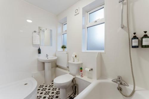 a white bathroom with a toilet and a sink at Stratford Great Rooms to stay - 20 in London
