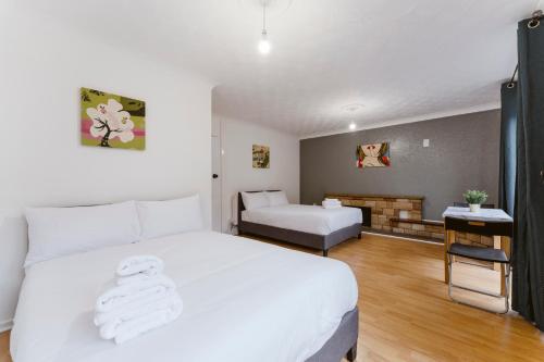 a bedroom with a white bed and a living room at Stratford Great Rooms to stay - 20 in London