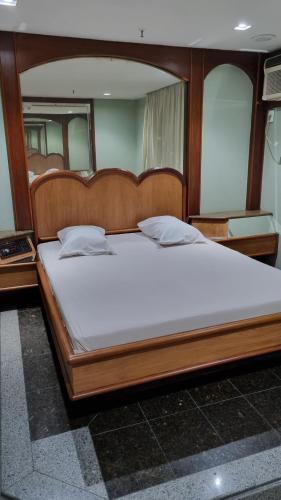 a large bed with a wooden frame in a room at STOP TIME HOTE in Rio de Janeiro