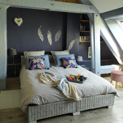 - une chambre avec un grand lit recouvert de plumes dans l'établissement Gite Arthur et Germaine Maisonnette à la campagne avec un grand jardin, à Saint-Jeoire-Prieuré